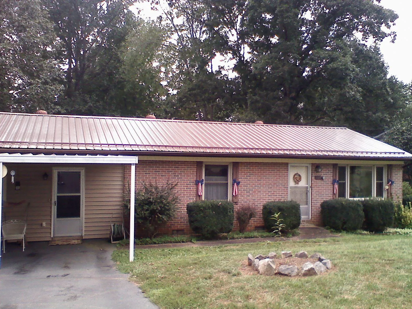 Bronze metal roof and carport on a brick ranch home — Roof Repair work by our crew in Athens